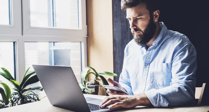 Mann sitzt an Notebook